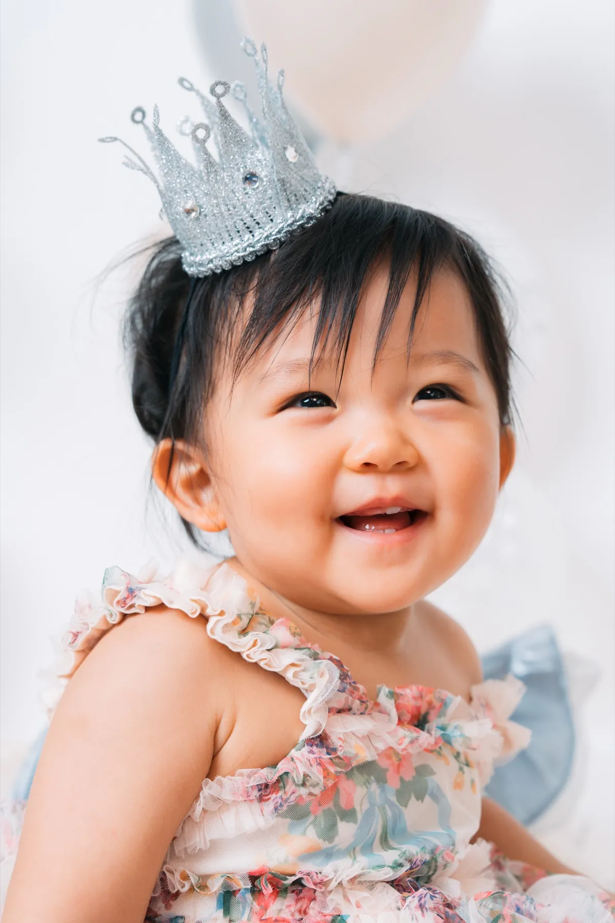 ティアラをつけて笑う1歳の女の子のクローズアップ